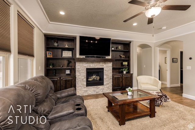 2691 E 3800 S, St George, UT 84790 - living room featuring a ceiling fan, a fireplace, wood finished floors, a textured ceiling, and arched walkways