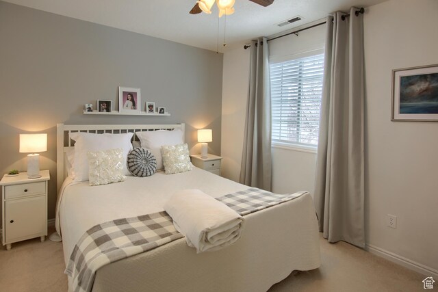 bedroom featuring a ceiling fan, baseboards, light colored carpet, and visible vents