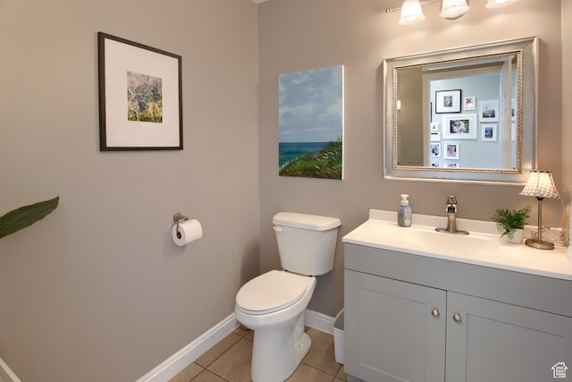 bathroom with toilet, baseboards, tile patterned flooring, and vanity