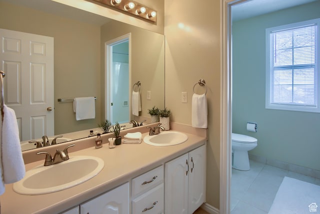 bathroom featuring a sink, tile patterned floors, toilet, and double vanity