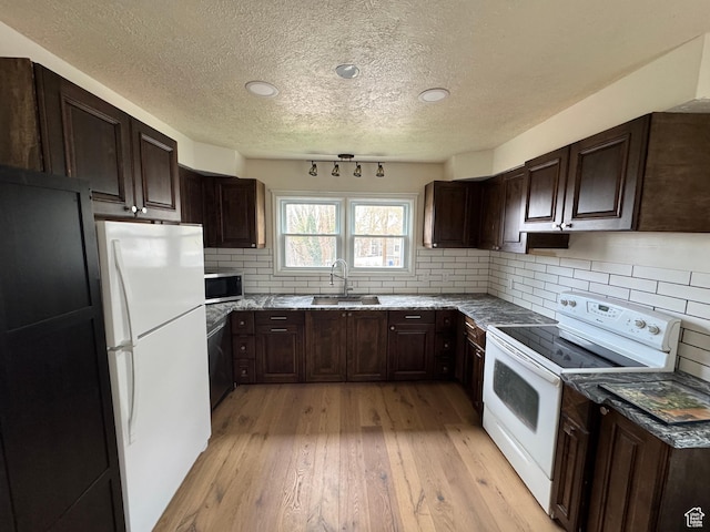 26 Sylvia Dr N, South Ogden, UT 84405 - kitchen featuring dark brown cabinetry, white appliances, light wood-style flooring, a textured ceiling, and a sink