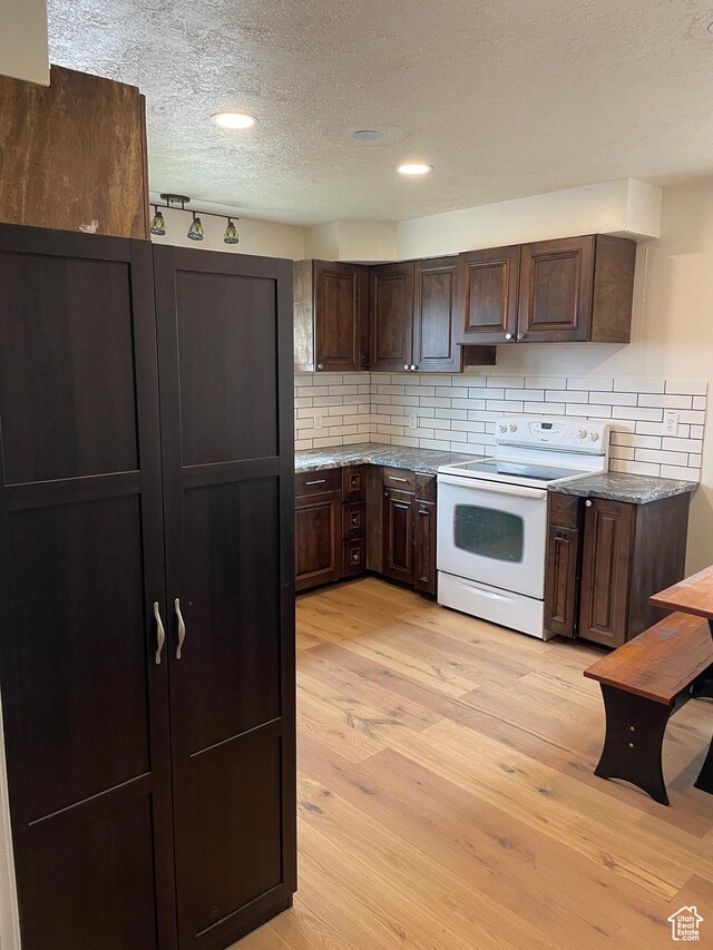 26 Sylvia Dr N, South Ogden, UT 84405 - kitchen with white range with electric cooktop, light wood finished floors, and dark brown cabinetry