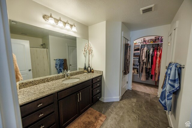 3951 W 1450 N Unit 269, Lehi, UT 84043 - bathroom featuring a shower, vanity, a walk in closet, a textured ceiling, and visible vents