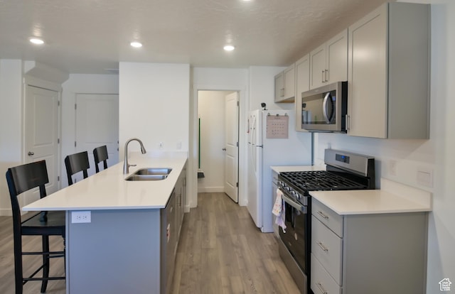 1088 E Propeller Row, Saratoga Springs, UT 84045 - kitchen featuring light wood-style flooring, a kitchen bar, stainless steel appliances, a sink, and gray cabinets