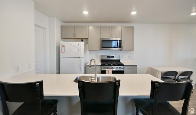 1088 E Propeller Row, Saratoga Springs, UT 84045 - kitchen featuring light countertops, a kitchen bar, recessed lighting, gray cabinets, and stainless steel appliances
