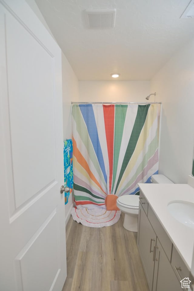 1088 E Propeller Row, Saratoga Springs, UT 84045 - bathroom featuring a shower with shower curtain, toilet, vanity, wood finished floors, and visible vents