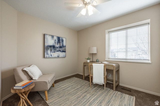 carpeted office space with baseboards and ceiling fan