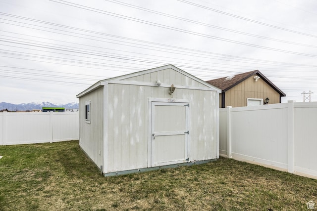 view of shed featuring a fenced backyard and a mountain view