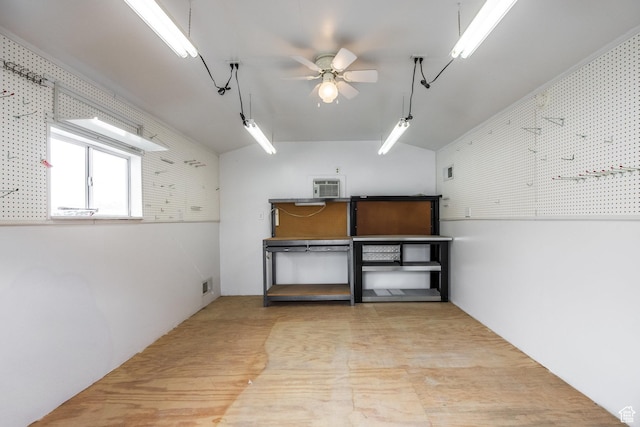 below grade area with wood finished floors, visible vents, a wall mounted AC, and ceiling fan