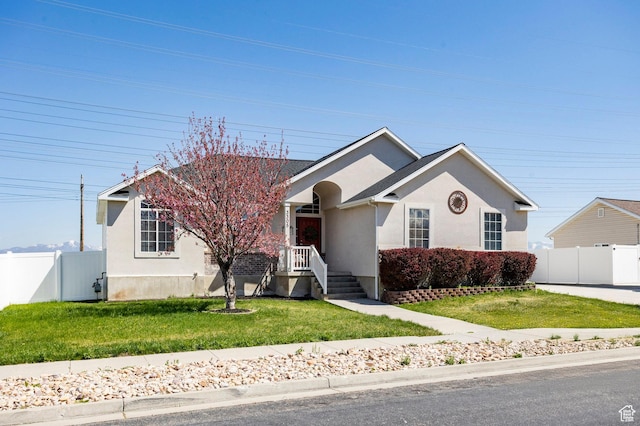 view of front of home featuring a front lawn, stucco siding, and fence