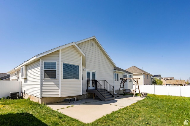 back of property featuring a yard, central AC, a patio, and fence
