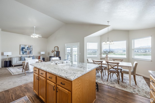 kitchen with a center island, vaulted ceiling, a wealth of natural light, and dark wood-style flooring