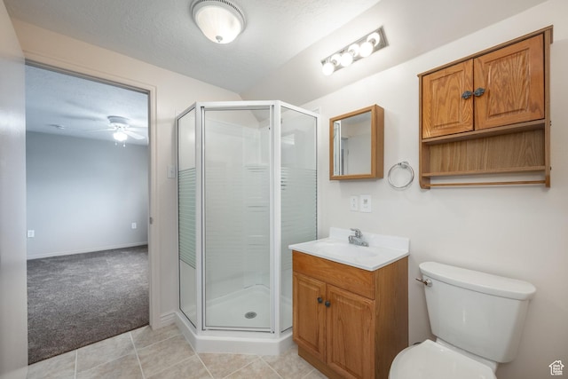 bathroom with ceiling fan, toilet, vanity, and a stall shower
