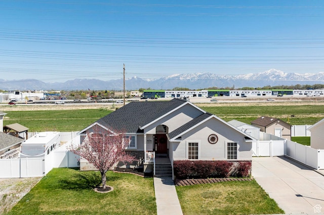 single story home with a gate, a front lawn, fence, and a mountain view