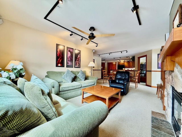 12080 E Big Cottonwood Rd Unit 214, Brighton, UT 84121 - living room featuring rail lighting, carpet floors, a ceiling fan, a stone fireplace, and baseboards
