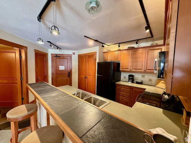 12080 E Big Cottonwood Rd Unit 214, Brighton, UT 84121 - kitchen featuring freestanding refrigerator, track lighting, range with gas cooktop, a sink, and a breakfast bar area