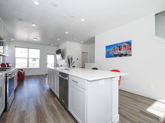 10638 S Pipestone Way W Unit 136, South Jordan, UT 84009 - kitchen featuring a sink, stainless steel appliances, recessed lighting, dark wood-style floors, and baseboards