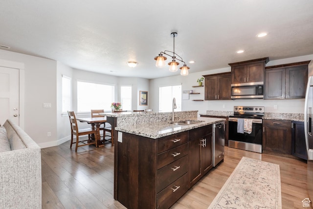 51 N 270 W, Hyrum, UT 84319 - kitchen featuring stainless steel appliances, a sink, light wood-style flooring, a kitchen island with sink, and dark brown cabinetry
