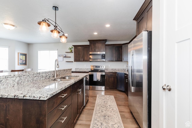 51 N 270 W, Hyrum, UT 84319 - kitchen featuring dark brown cabinetry, an island with sink, a sink, and appliances with stainless steel finishes