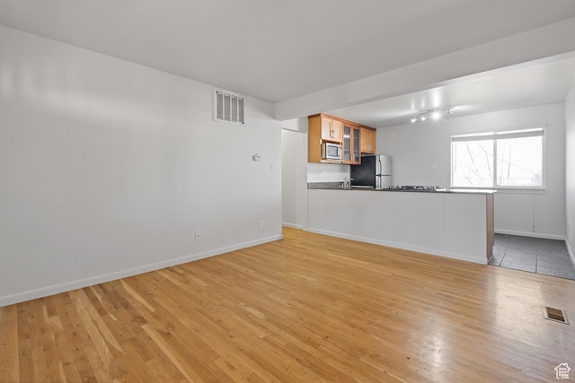 650 N 300 W Unit 231, Salt Lake City, UT 84103 - unfurnished living room with baseboards, visible vents, and light wood-type flooring