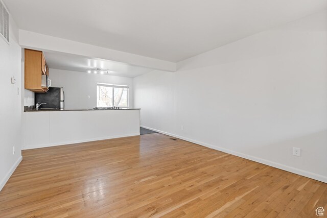 650 N 300 W Unit 231, Salt Lake City, UT 84103 - unfurnished living room with baseboards and light wood-type flooring