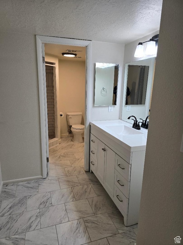 1039 E Quail Vista Ln Unit A, Millcreek, UT 84117 - bathroom with toilet, vanity, a textured ceiling, marble finish floor, and baseboards