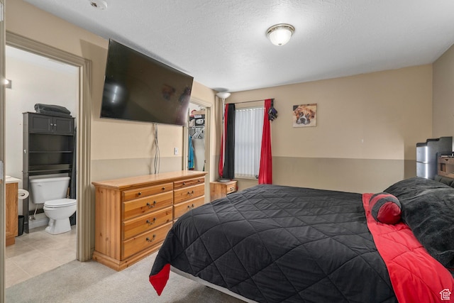 bedroom featuring light colored carpet and ensuite bathroom
