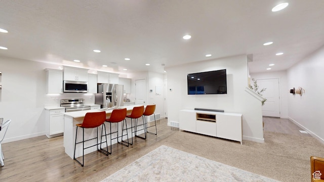 14952 S Messi St, Herriman, UT 84096 - kitchen with baseboards, stainless steel appliances, recessed lighting, an island with sink, and a kitchen breakfast bar