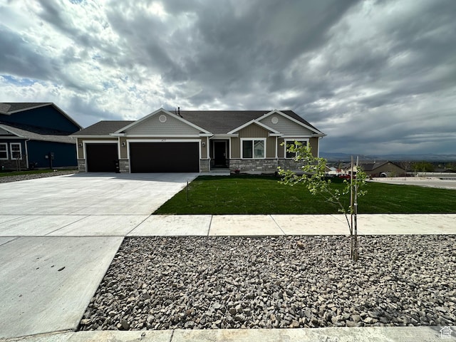 437 N 800 E, Hyde Park, UT 84318 - craftsman house featuring stone siding, concrete driveway, a front yard, and a garage
