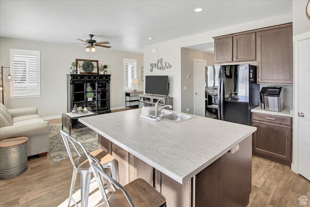 5197 W Copeland Dr S, Herriman, UT 84096 - kitchen featuring open floor plan, black fridge with ice dispenser, a sink, light wood finished floors, and a ceiling fan