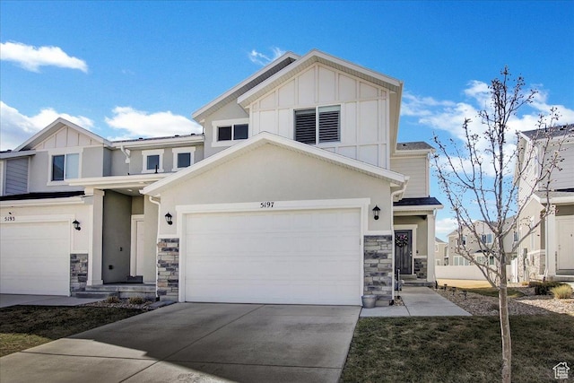 view of front of property featuring stone siding, concrete driveway, stucco siding, board and batten siding, and a garage