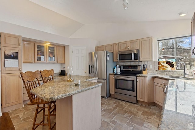 846 E Holroyd S, South Ogden, UT 84403 - kitchen with light stone countertops, a kitchen bar, appliances with stainless steel finishes, a sink, and vaulted ceiling