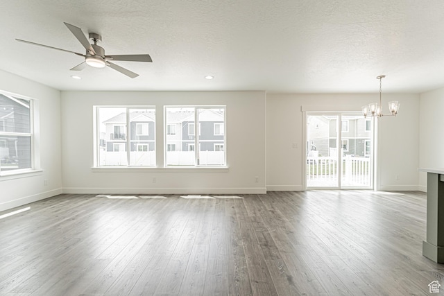 3671 W 950 N Unit 218, Lehi, UT 84043 - unfurnished living room with a chandelier, wood finished floors, a ceiling fan, and a textured ceiling
