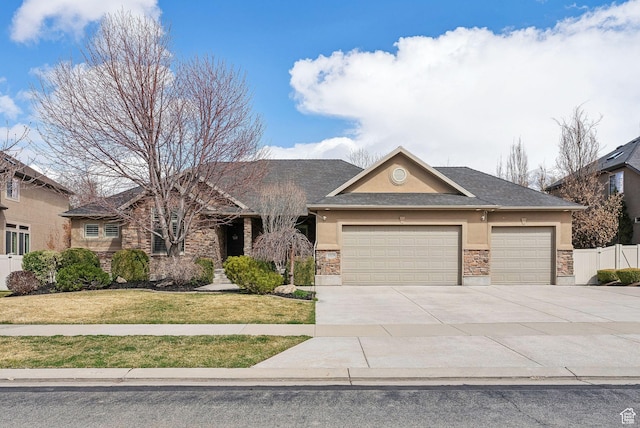 view of front of house featuring driveway, a front yard, stucco siding, fence, and a garage