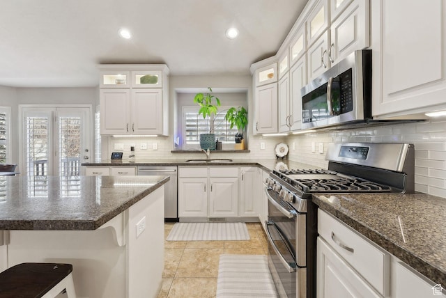 kitchen featuring a sink, tasteful backsplash, appliances with stainless steel finishes, and white cabinetry
