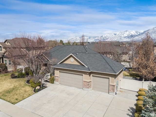 view of front of home featuring stucco siding, a front lawn, a gate, a garage, and driveway