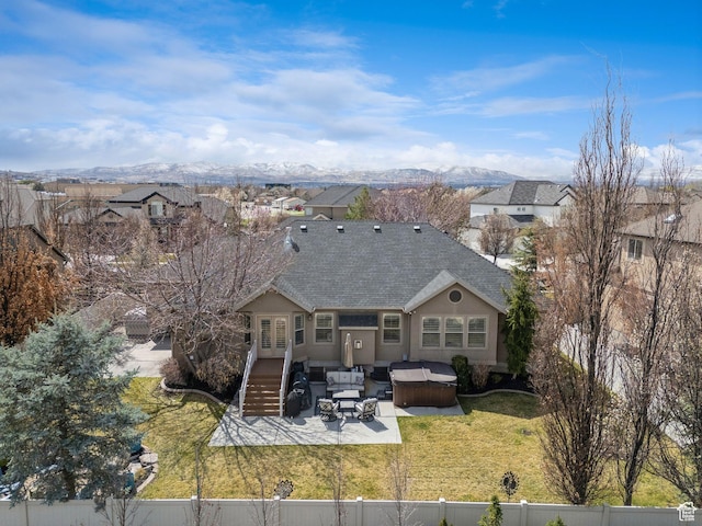 back of house with a mountain view, a patio area, a fenced backyard, an outdoor hangout area, and a yard