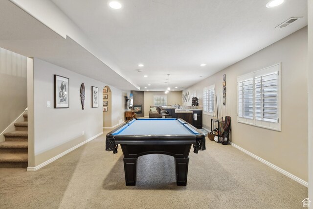 recreation room featuring baseboards, recessed lighting, bar area, and light carpet
