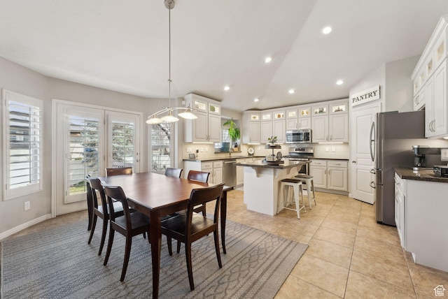 dining space featuring light tile patterned floors, baseboards, recessed lighting, and lofted ceiling