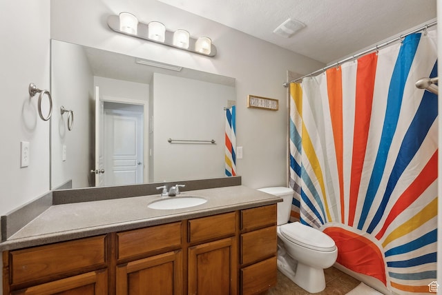 bathroom featuring a textured ceiling, vanity, visible vents, toilet, and tile patterned floors