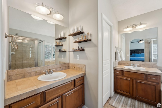 bathroom with a sink, two vanities, a shower stall, and ensuite bath