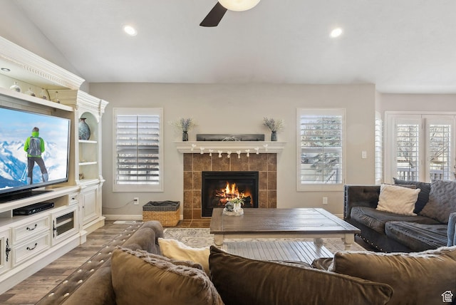 living area featuring wood finished floors, ceiling fan, a fireplace, and recessed lighting