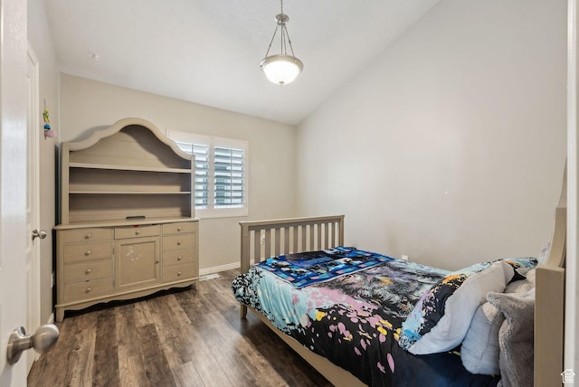 bedroom featuring dark wood-style flooring, baseboards, and lofted ceiling