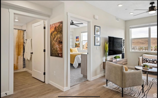 875 W Akoya Pearl St Unit 303, St George, UT 84790 - living room featuring light wood finished floors, baseboards, visible vents, and a ceiling fan