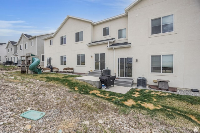 864 N Gleneagles Ct W, Tooele, UT 84074 - back of house with a patio, central AC, stucco siding, and entry steps