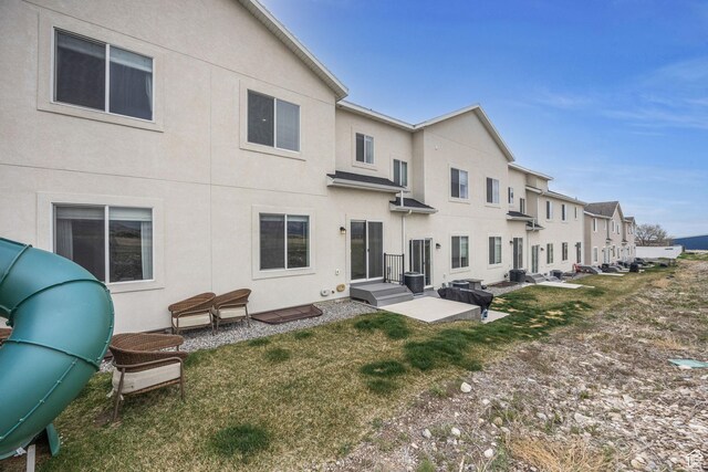 864 N Gleneagles Ct W, Tooele, UT 84074 - back of house with stucco siding, central air condition unit, and a lawn