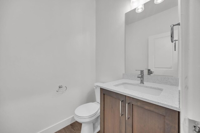864 N Gleneagles Ct W, Tooele, UT 84074 - bathroom with baseboards, wood finished floors, toilet, and vanity