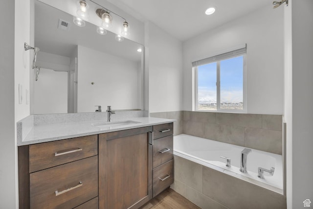 864 N Gleneagles Ct W, Tooele, UT 84074 - bathroom featuring visible vents, wood finished floors, recessed lighting, vanity, and a garden tub