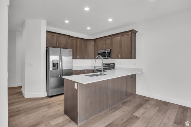 864 N Gleneagles Ct W, Tooele, UT 84074 - kitchen with light countertops, light wood-style floors, a peninsula, and appliances with stainless steel finishes