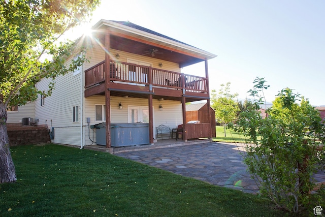 98 E Mt Peale Dr, Moab, UT 84532 - rear view of house featuring cooling unit, a hot tub, a patio area, ceiling fan, and a lawn